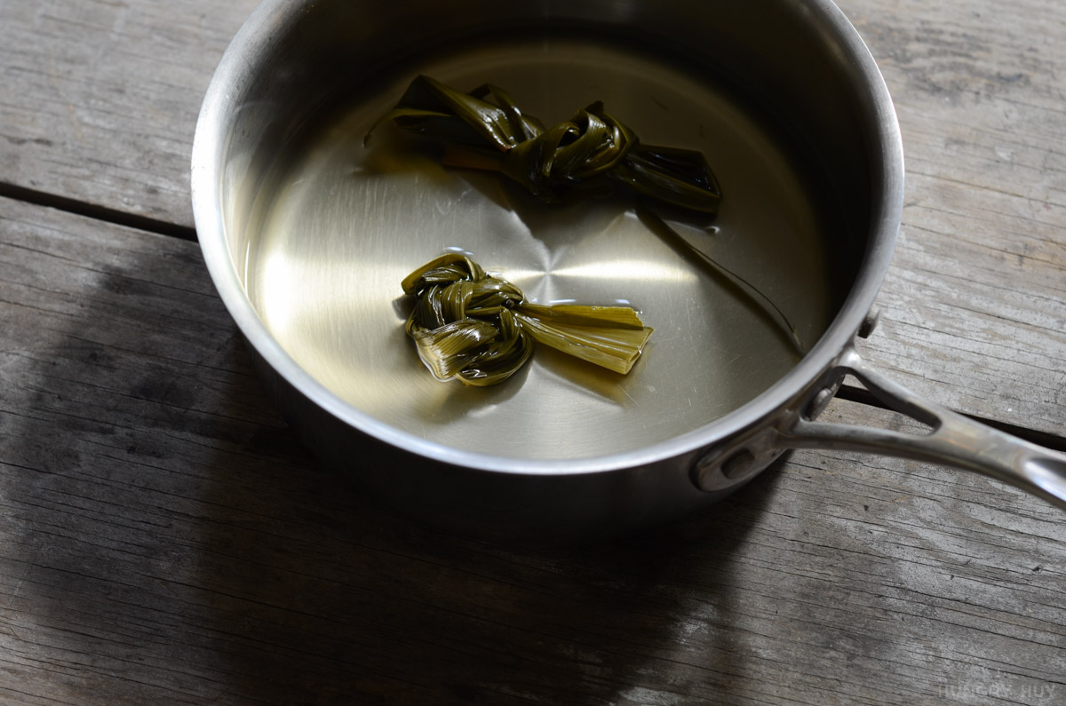 pandan leaves tied into knots in a pan