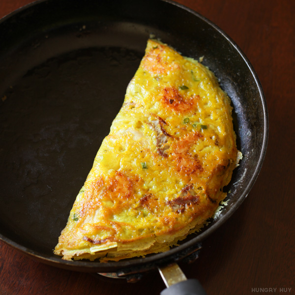 Close-up of crisped banh xeo in a pan | HungryHuy.com