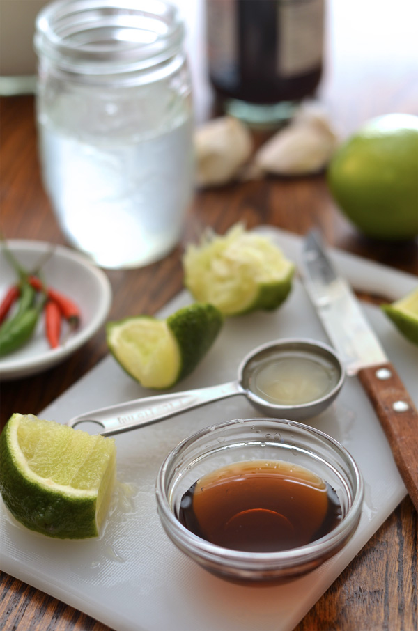 slicing limes and measuring fish sauce for nước chấm